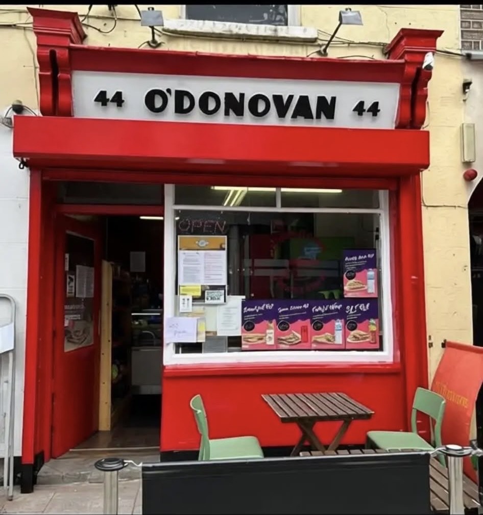The red shopfront of O'Donovan Cafe at 44 Pearse Street, Dublin, with outdoor seating